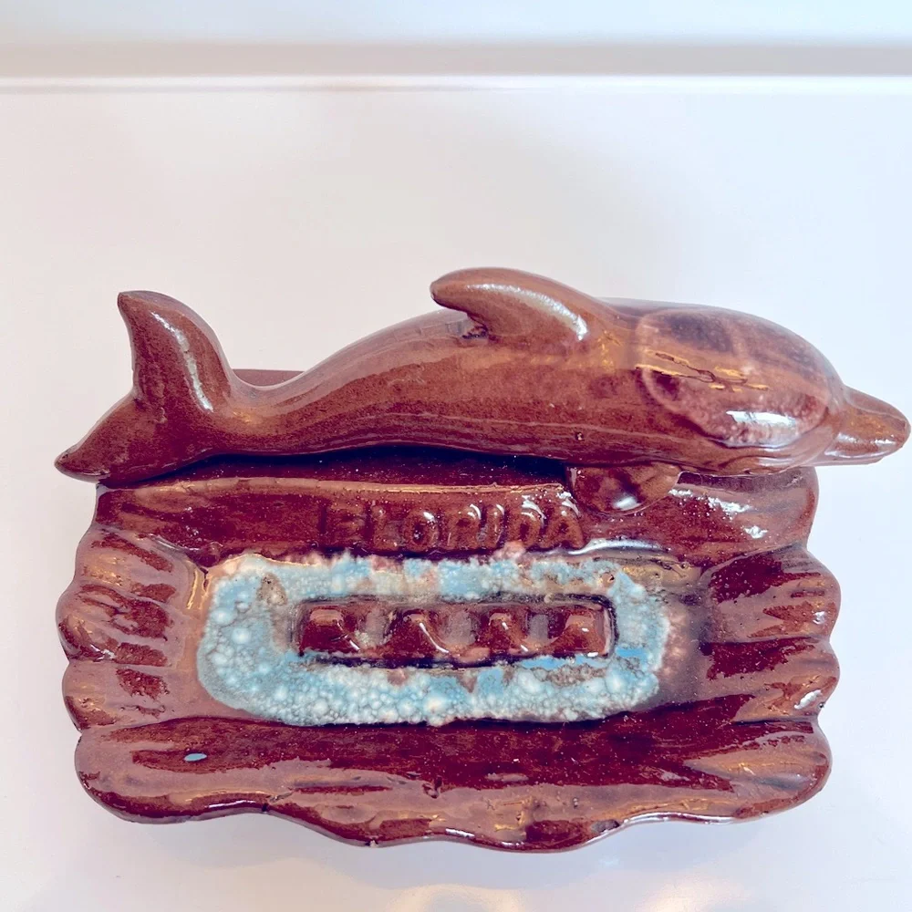 Vintage Ceramic Florida Ashtray with a Brown Dolphin Swimming in Blue Water.